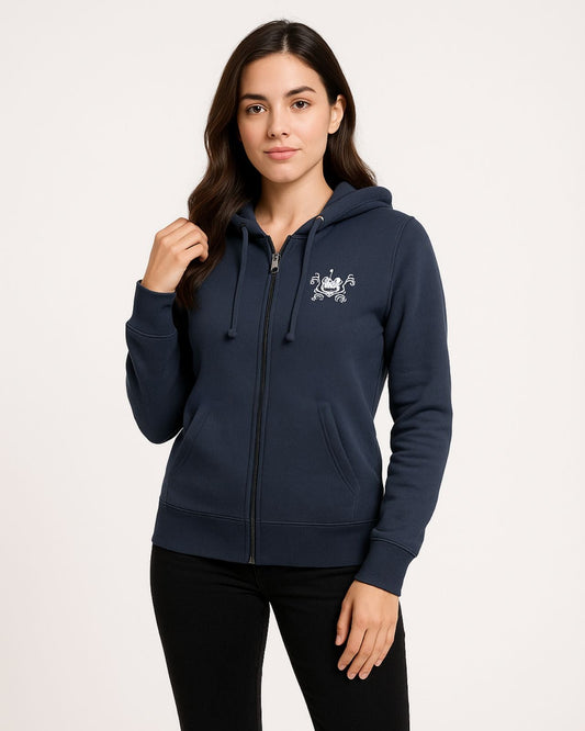 A woman wearing a navy hooded jacket with a small emblem, posing confidently against a plain background. Her expression is calm and self-assured.