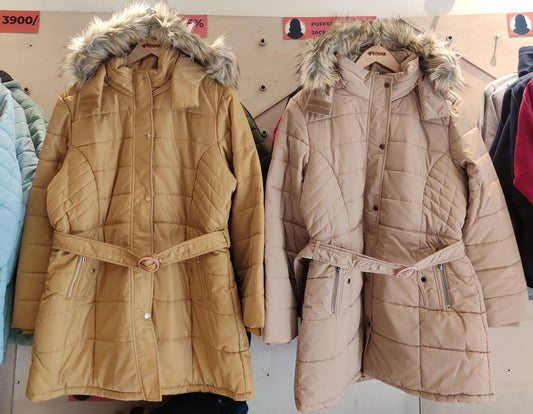 Tan and beige women’s belted puffer jackets with faux fur hoods displayed at Kosha’s winter wear store.