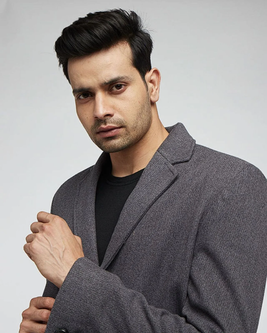 Man wearing a grey textured winter blazer over a black t-shirt from Kosha’s collection.