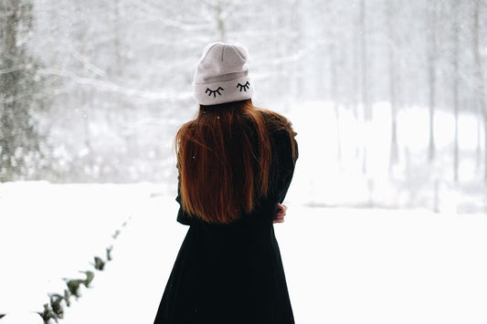 A woman in the snow, enjoying while the winter wear does it job.